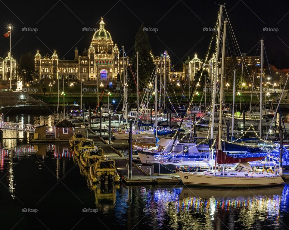 Downtown Victoria and the harbour at night - sailboats and the government building lit up 