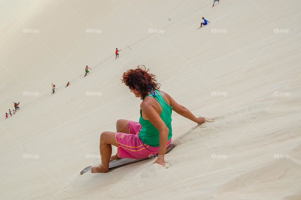Woman on skate on white sand dunes 