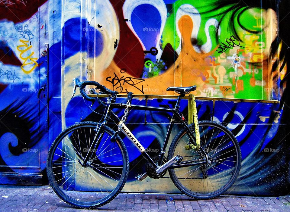 Bicycle in Amsterdam . I took this photo in the City of bicycles Amsterdam in front of a graffitied wall.