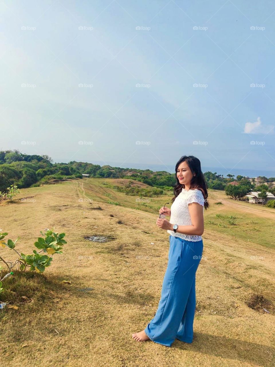 Portrait of young woman on holiday in the meadow during the day