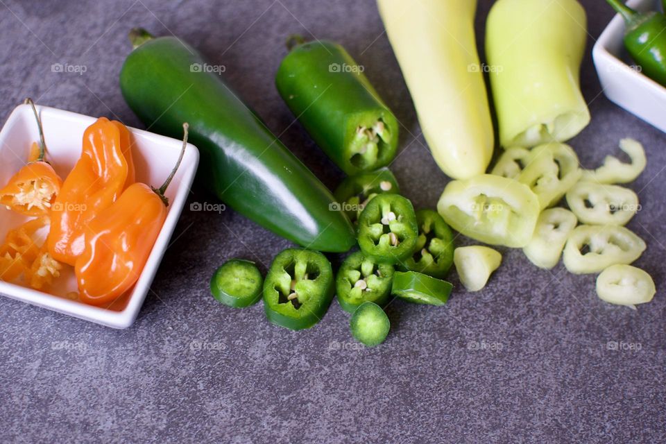 Close up of cut peppers on a slate background 