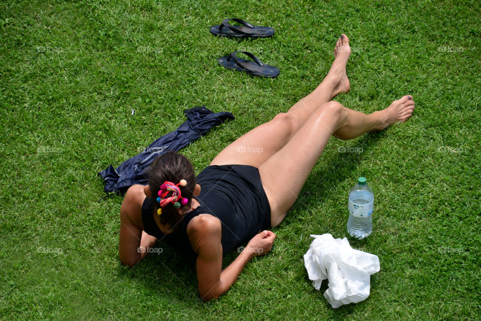 a woman relaxes lying on a grass