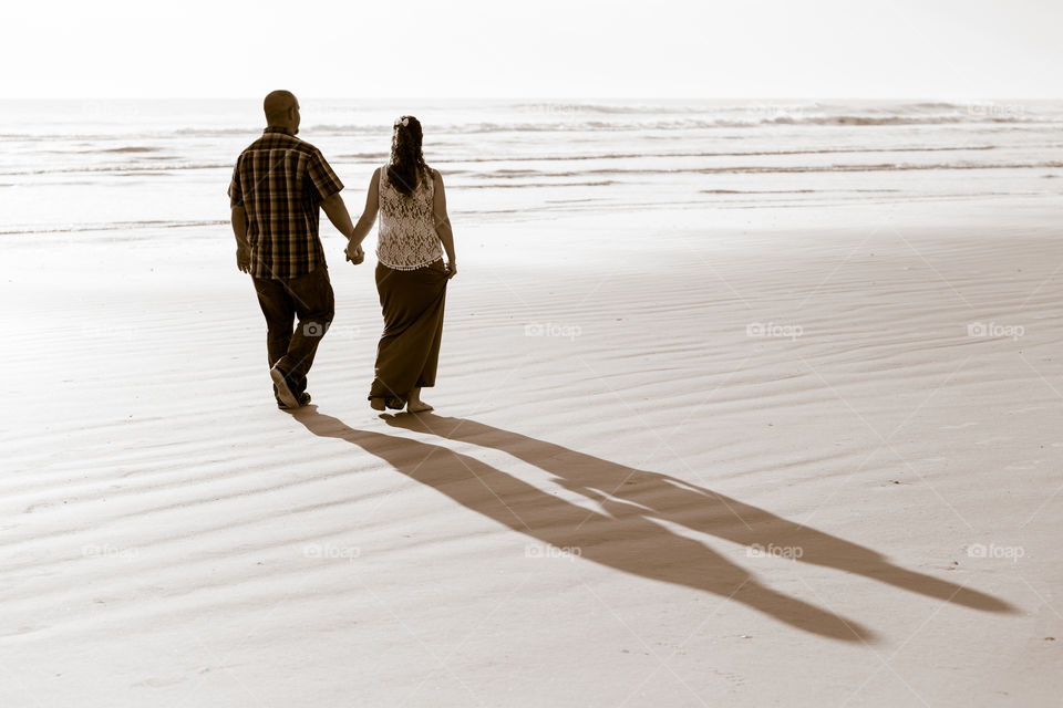 A Walk on the Beach . Couple walking on the beach hold hands 