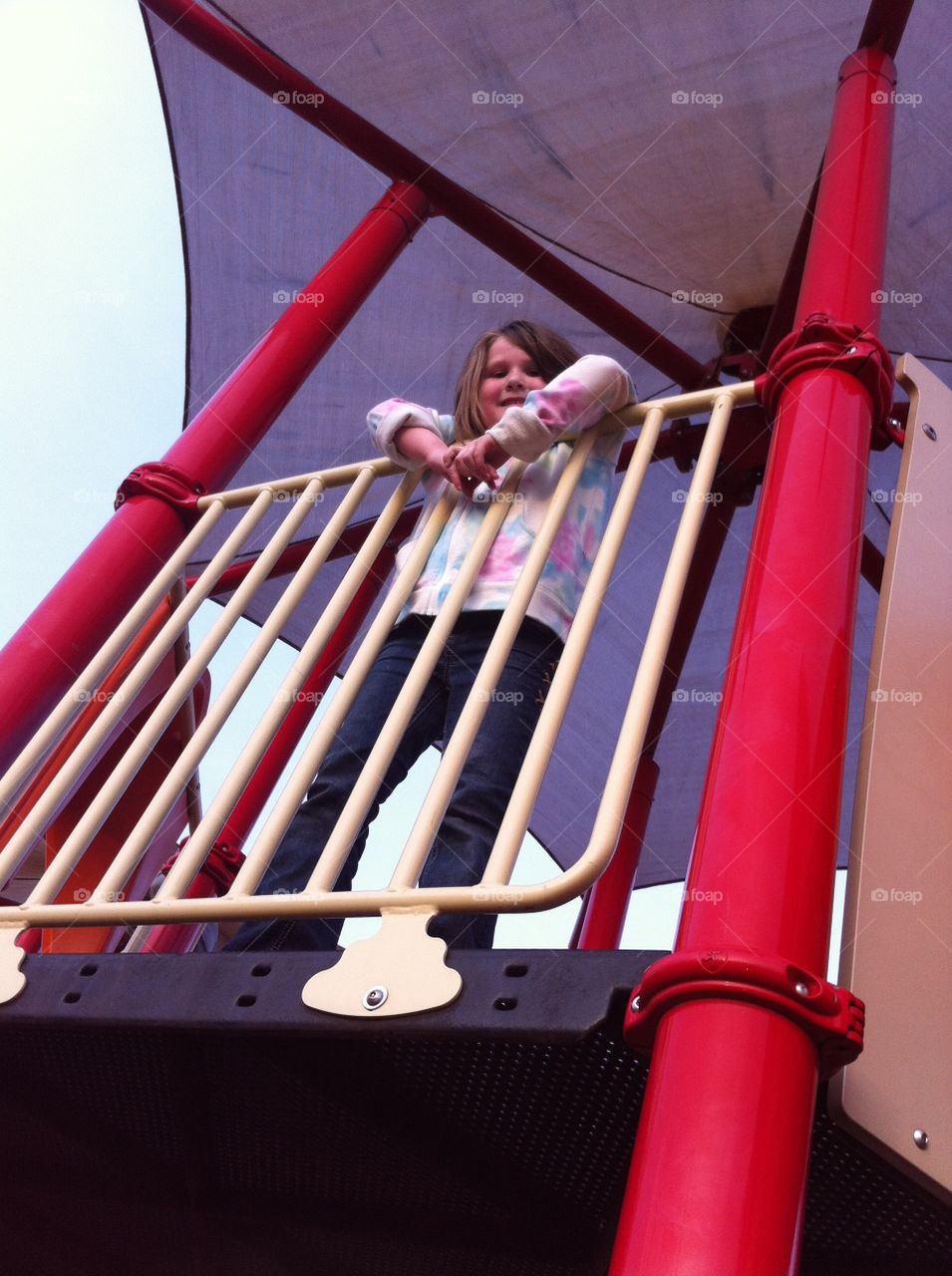 Looking up. Beautiful girl playing at the park.