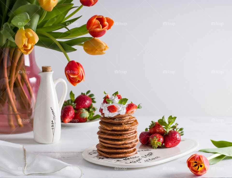 Pancakes with whipped cream and strawberries. 