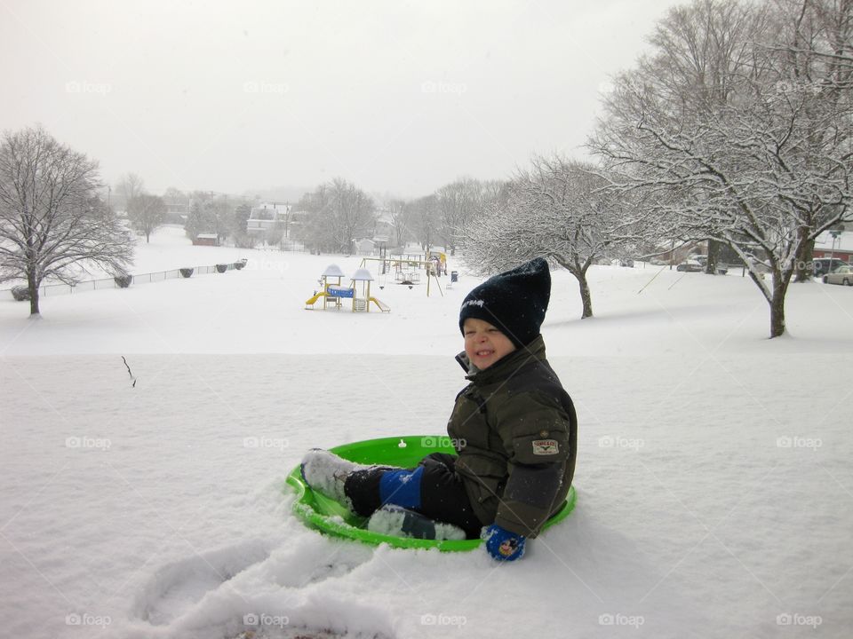 Child playing in snow during winter