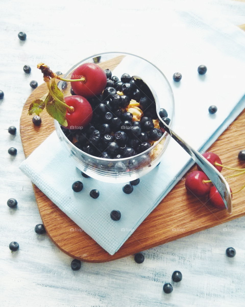 Muesli with berries. Muesli with blueberries and cherries on glass