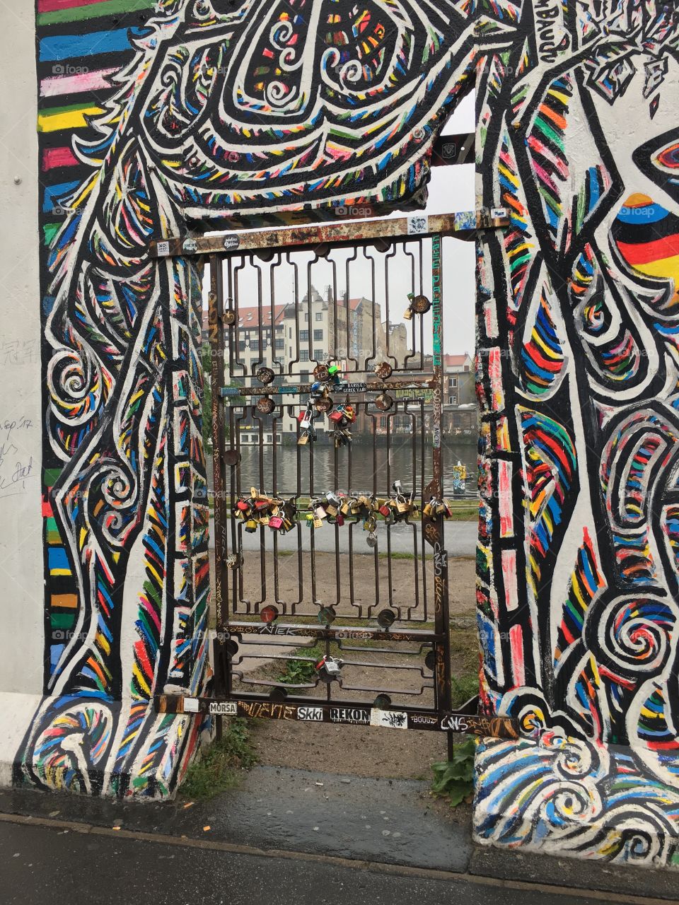 Locks attached to a wrought iron door in a remaining section of the Berlin Wall. 