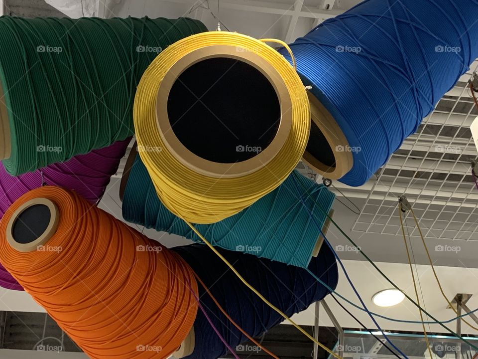 Decor of different color rolls of string.  Larger than life.  Look up
