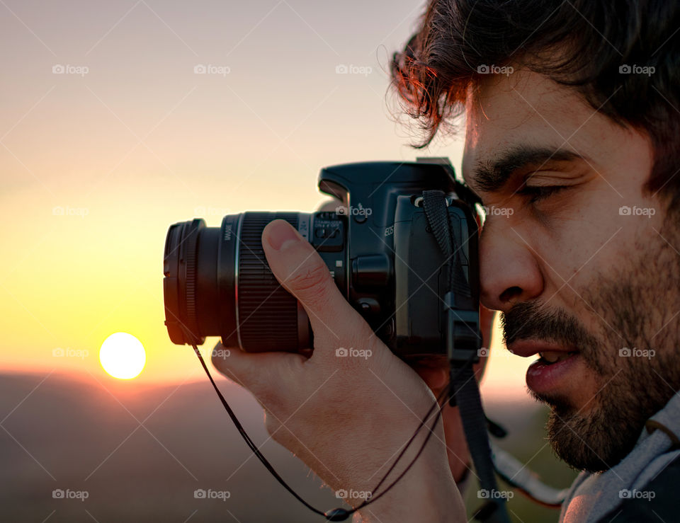 Photographer taking pictures against sunset