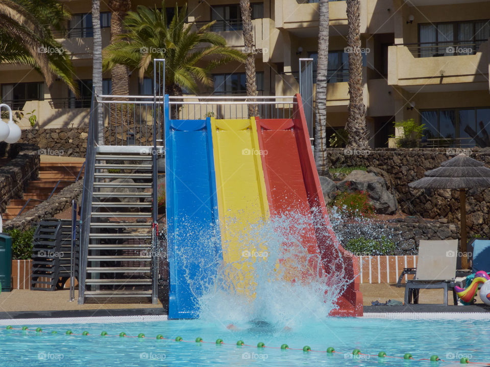 water splash created by jumping down a slide into a pool