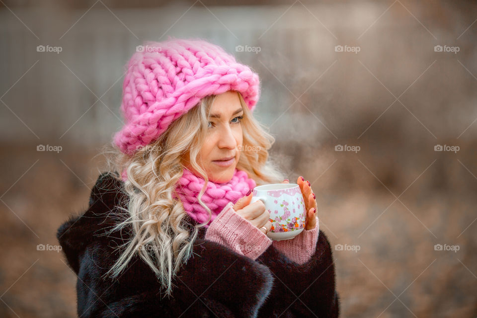 Outdoor Portrait of blonde woman in pink crochet accessories 