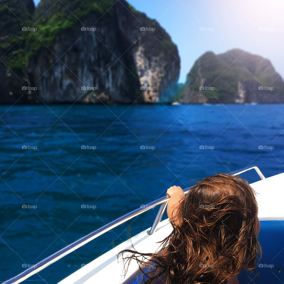 Young woman traveling to the tropical islands in the boat 