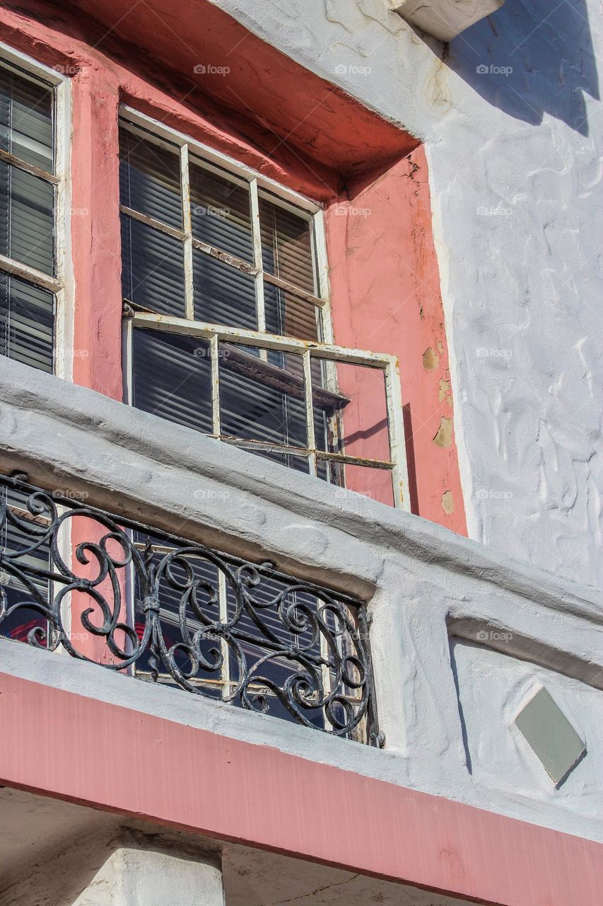 View looking up at a classic San Francisco marina district building, Spanish and art deco influences with greys and pale pink.