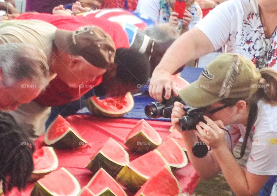 Photographer taking pics of watermelon contest  