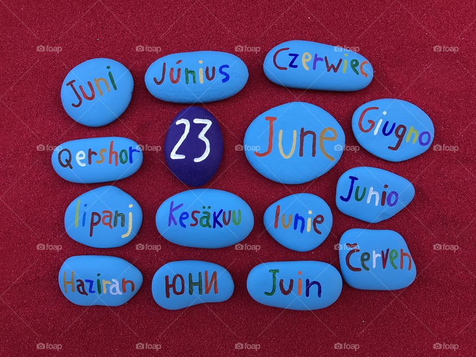  23 June, calendar date in many languages with colored stones and red background 