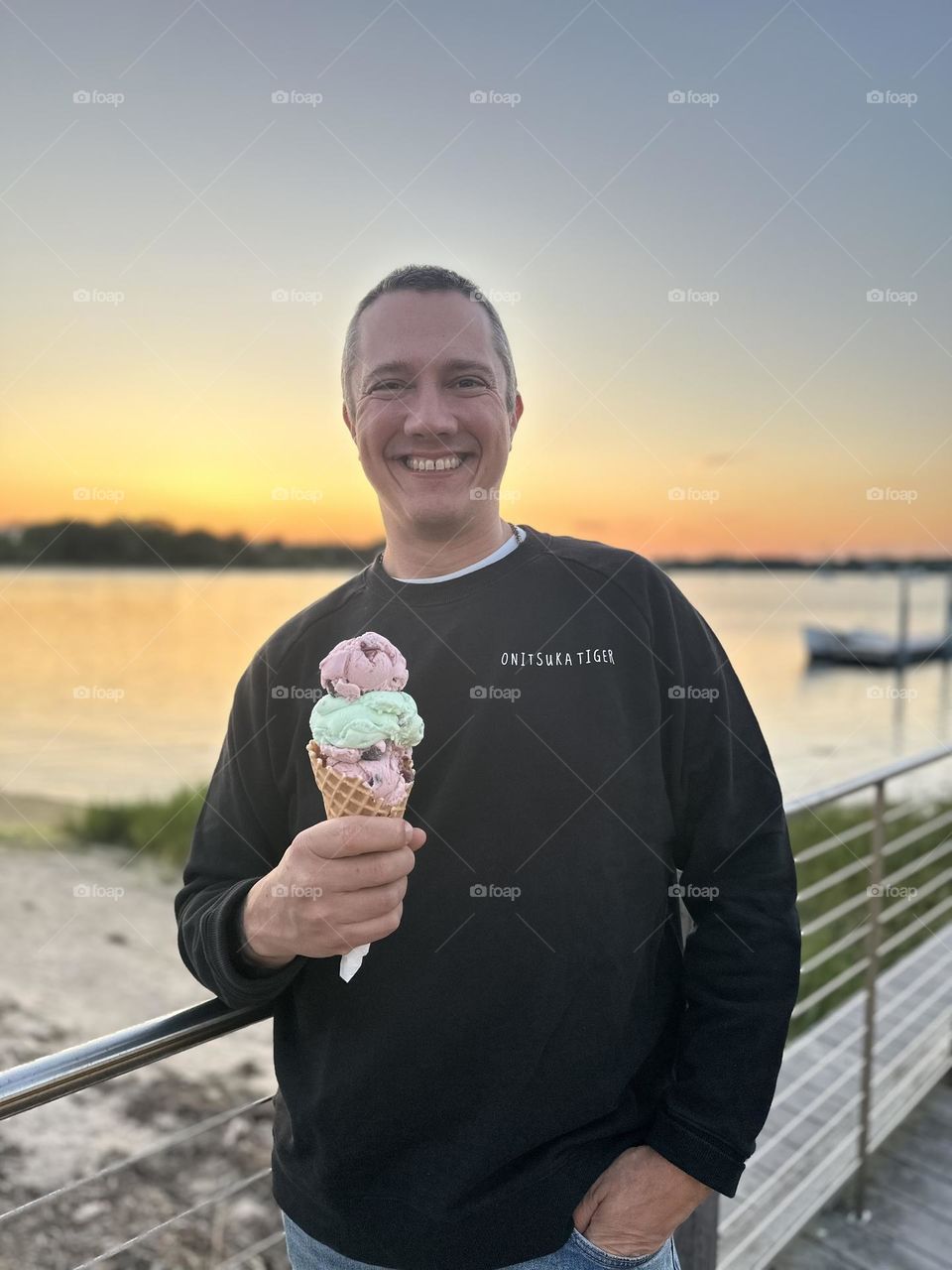 Dad eating ice cream by a lake, father enjoys ice cream cone, getting ice cream with the kids, fun at the beach with ice cream, eating out with Dad, fun with fathers 