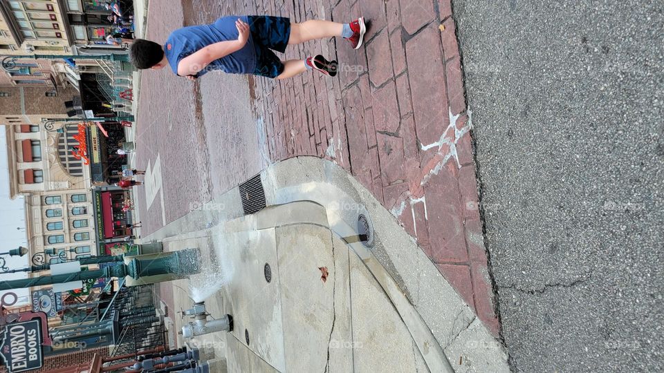running through water hydrant spray