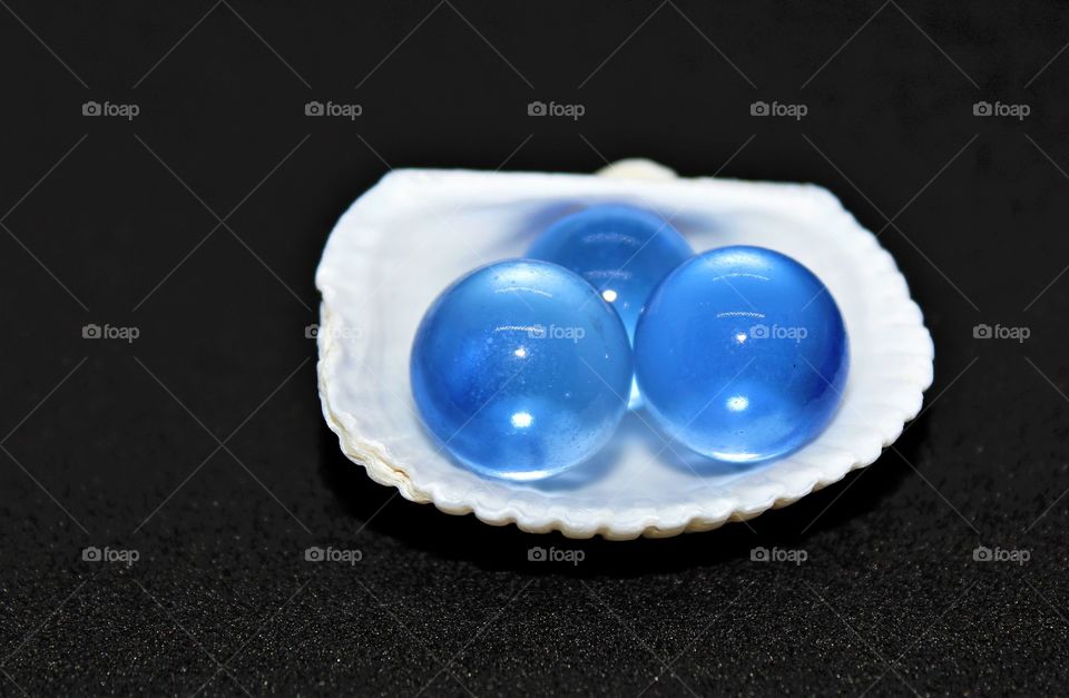 3 blue orbs in a half shell studio shot with black background