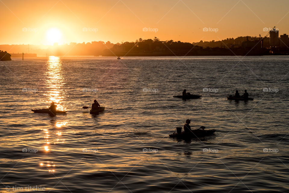 Bobbing in Sydney Harbour like corks in a bucket, these lucky tourists pause to take in a clear sunrise. 