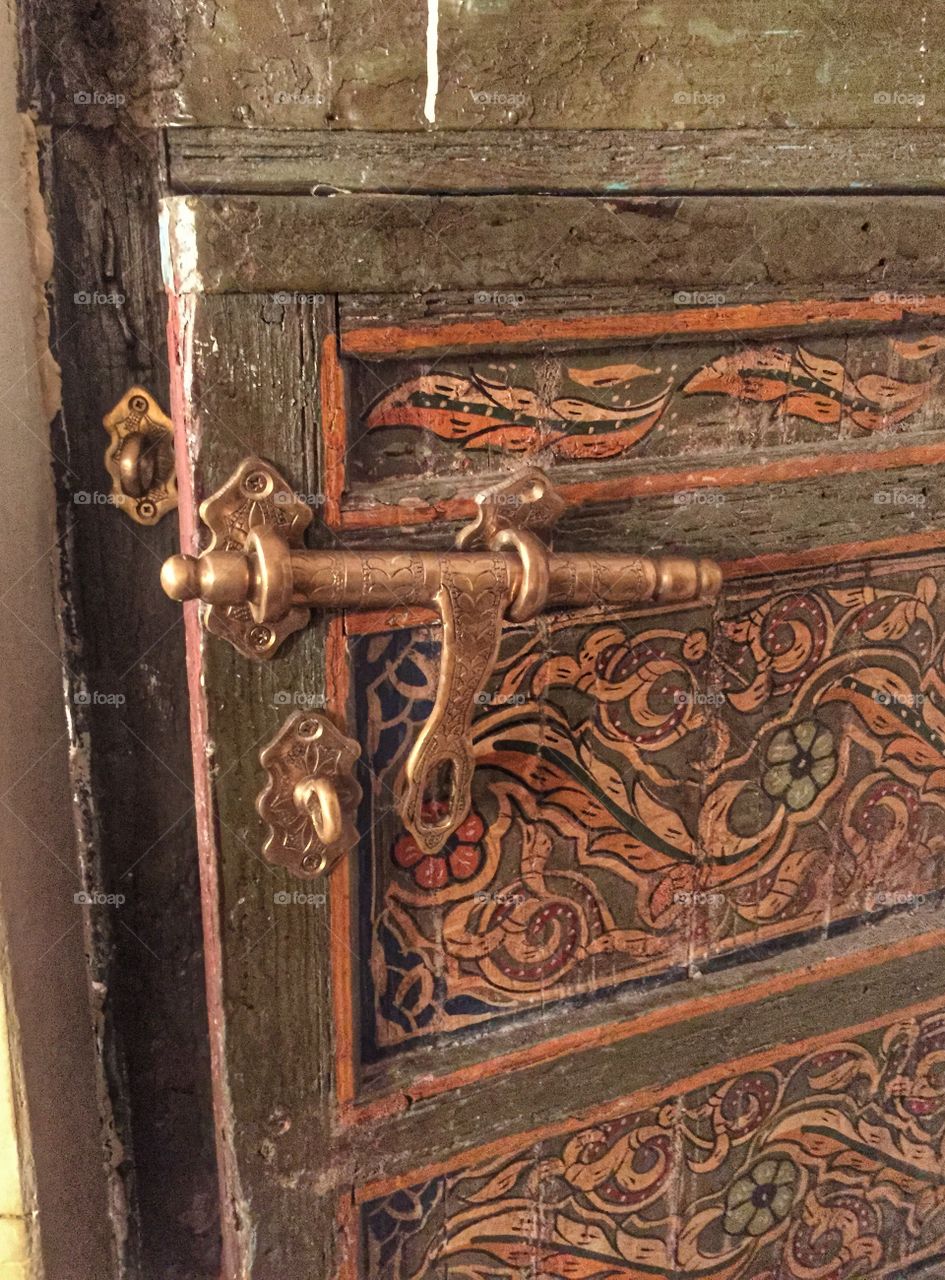 Close up of a bolt on an ornate Moroccan door.