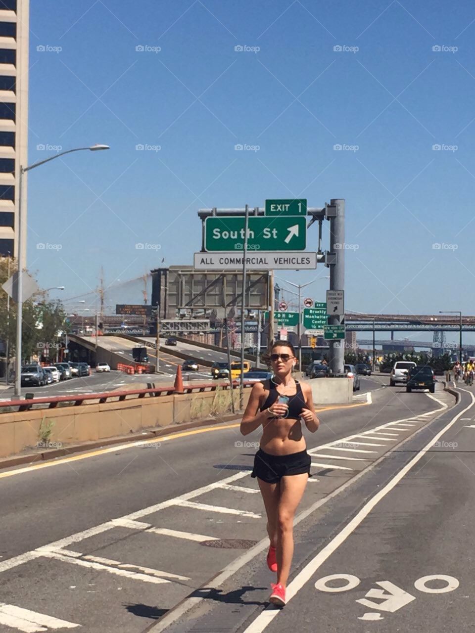 Running in New york city. A woman running trough Manhattan with earplugs in
