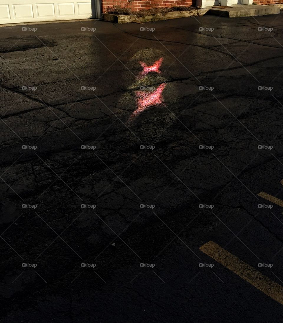 Red glare on black parking lot pavement 