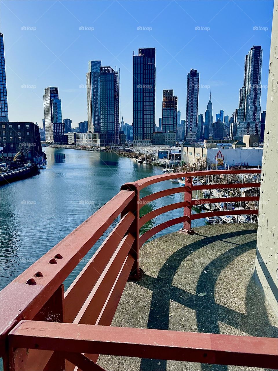 These curves come to us from the central outpost of the “Pulaski Bridge” at “Newtown Creek” that connects “Greenpoint”, Bklyn to LIC. Across the water we see LIC and further away “Manhattan” incl. the “Empire State Bldg”. 2024. Hypnotic Productions