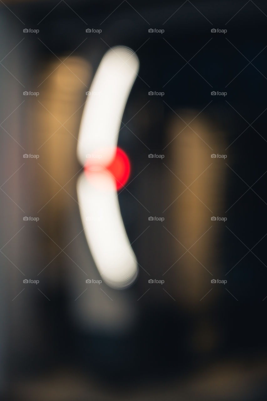 Der rote Punkt. Lichter in der Nacht mit einem Bokeh Effekt durch Unschärfe. Hochkant. Farbgebung rot, weiß und braun.