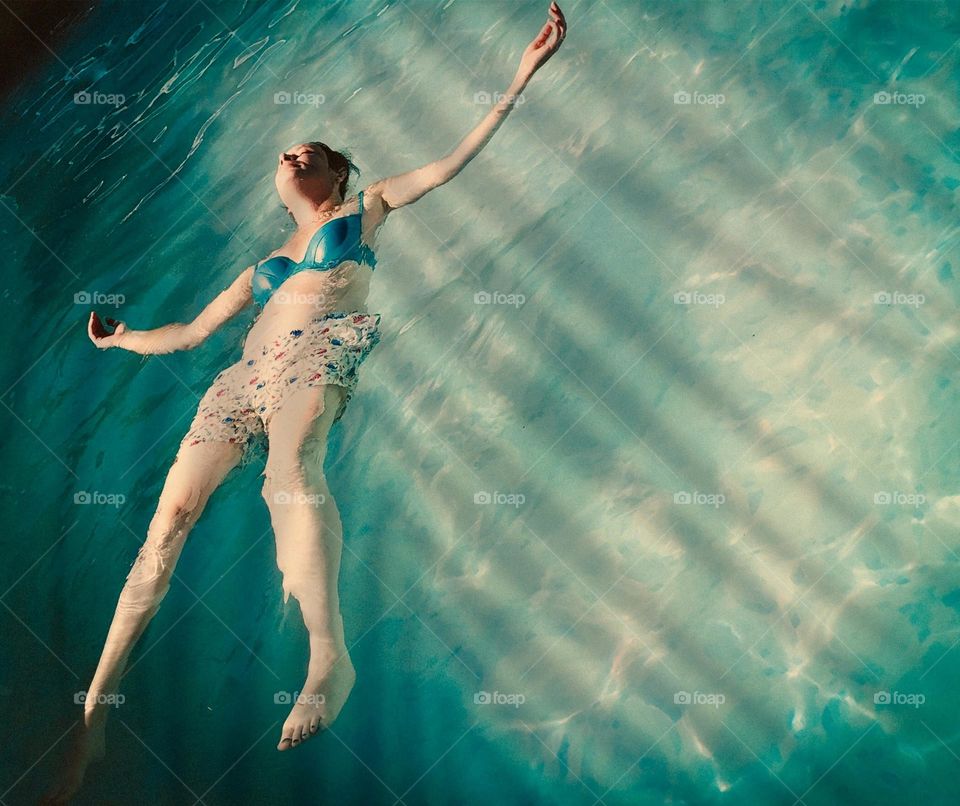 Woman floating in a swimming pool