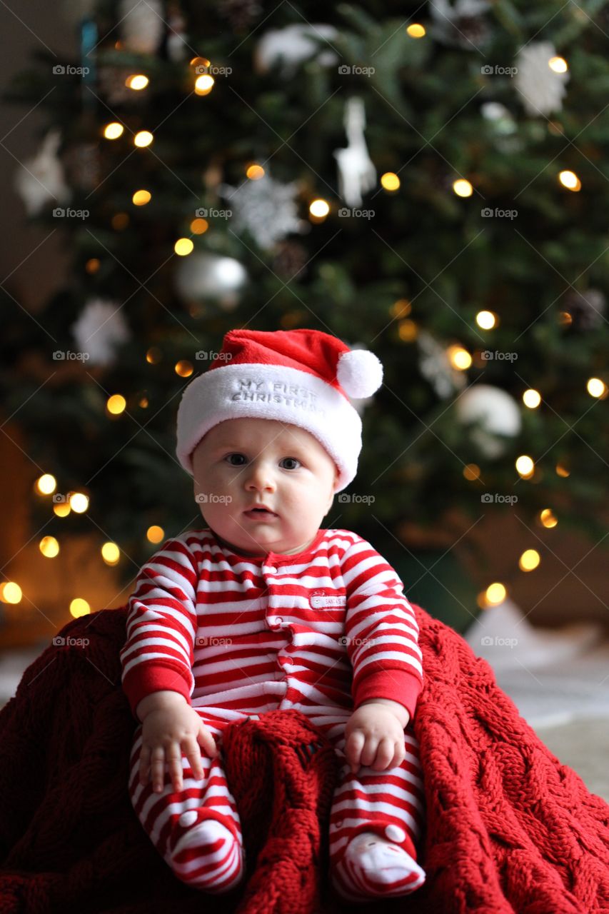Baby sitting in front of Christmas tree