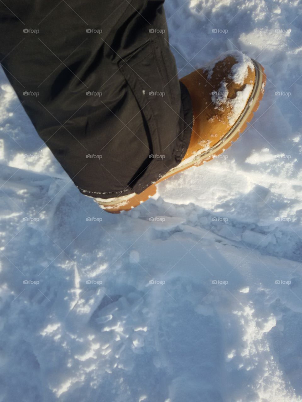 yelllow winter boot on  snow