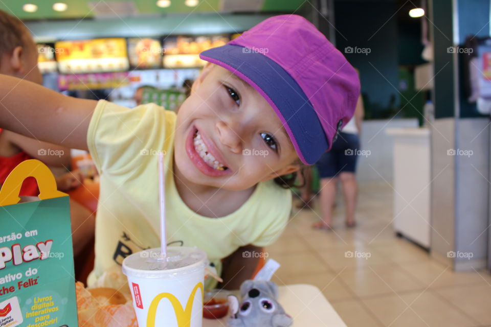 little happy girl eating at McDonald's