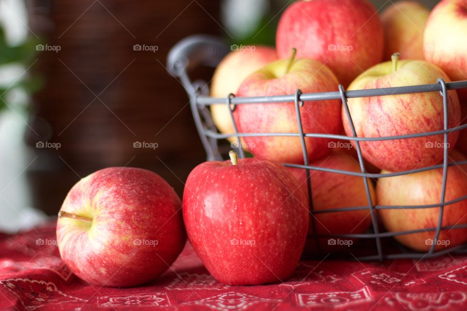 Fruits - apples in a wire basket on red bandana-print fabric