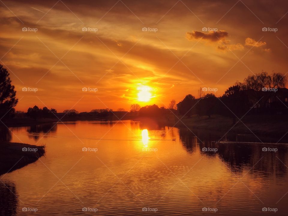 A Kansas sunset in the spring, reflecting over water