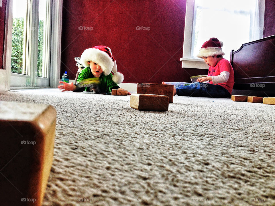 Two young brothers playing with presents at home on Christmas morning