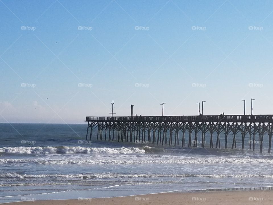 fishing pier and waves at the beach