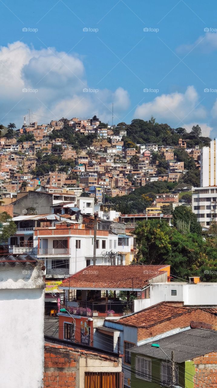 Cityscape in Santiago de Cali, Colombia, view from a balcony. Sunny and clear day. Building over the mountain