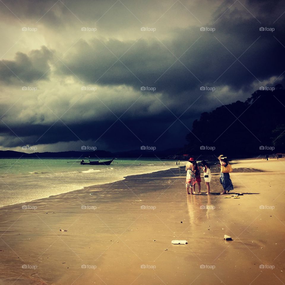 Women talking, stormy weather. In Krabi, Thailand I came across this beach with the women talking seemingly not knowing the weather had just turned.