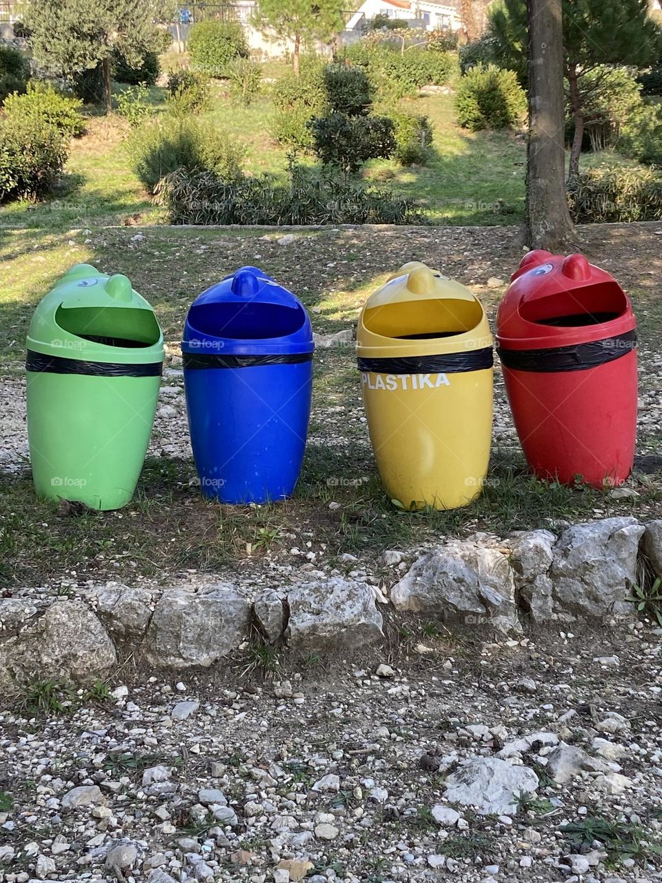 Cheerful, happy, colorful trash cans waiting patiently to dispose of your trash.