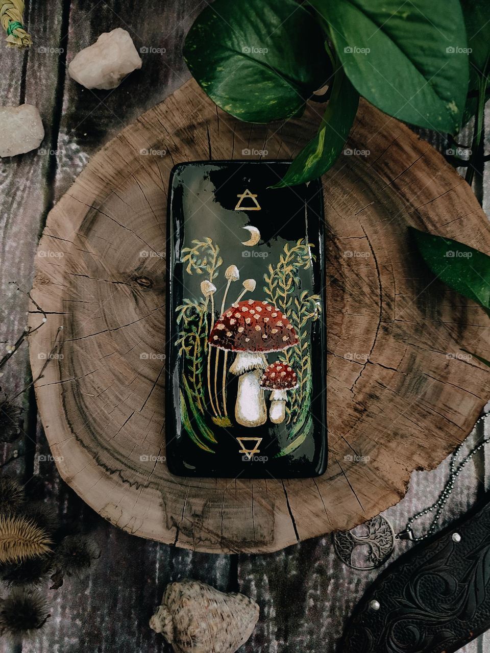 Black ceramic stand with red mushrooms amanita muscaria painting. Clay craft, drawing, art. Magical symbols, mysterious forest