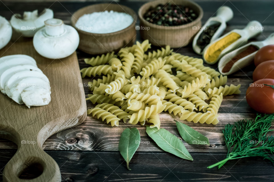 Raw pasta with ingredients and wooden accessories