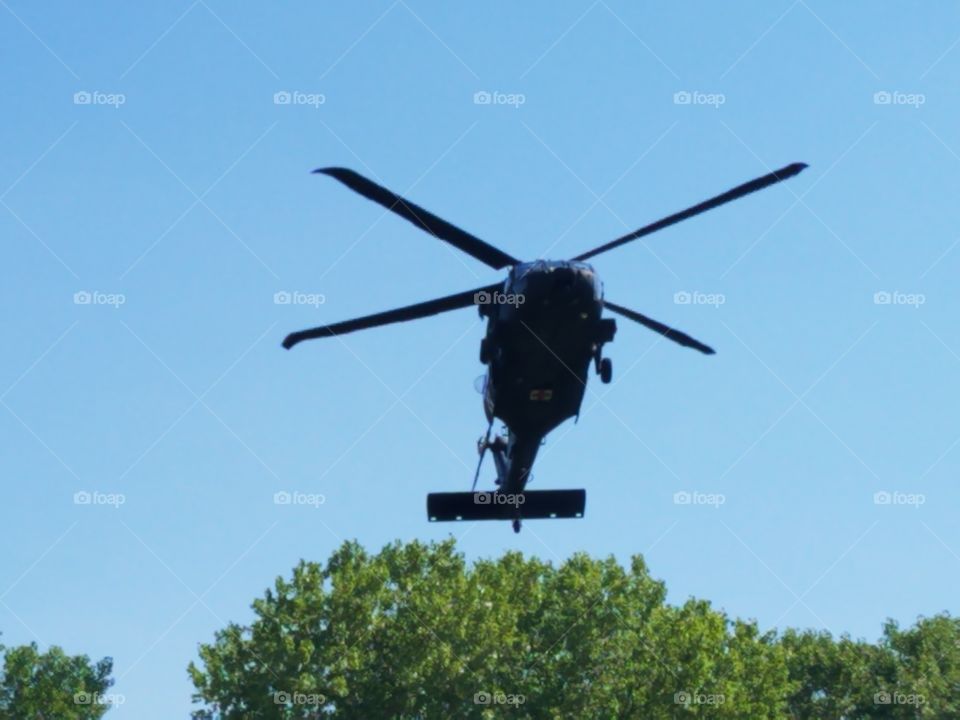 Blackhawk helicopter hovering over nearby trees, preparing to land for a MEDEVAC training mission
