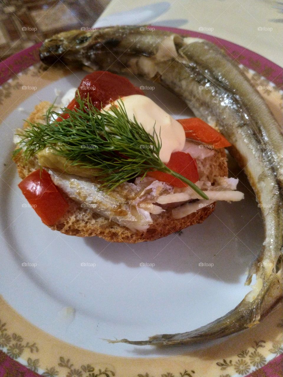 Sandwich with sea fish and vegetables with herbs.