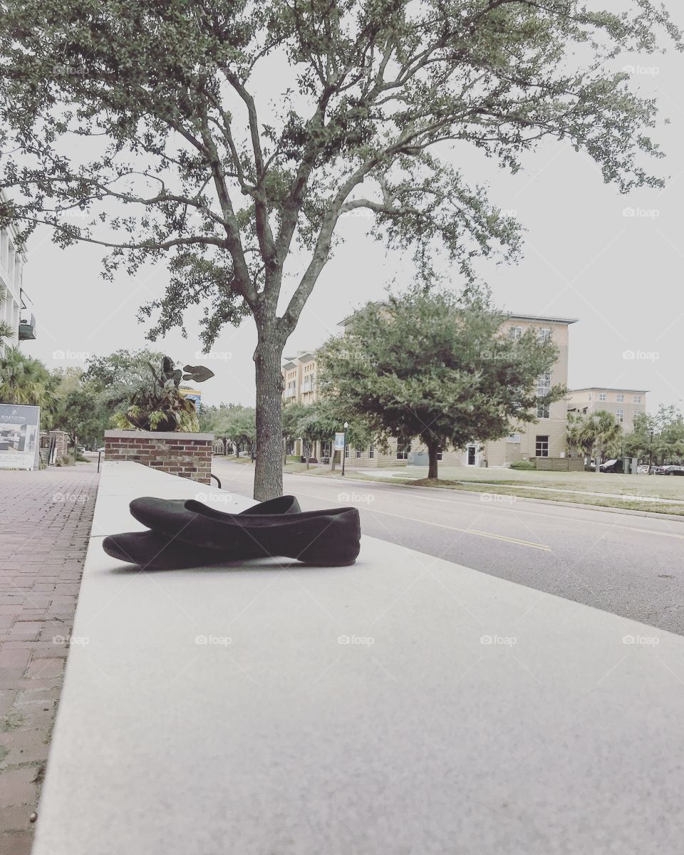 Black flats resting on the sidewalk in the suburbs