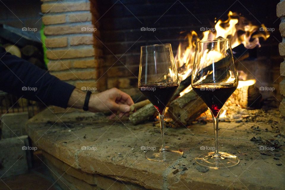 two glasses of red wine and the fireplace