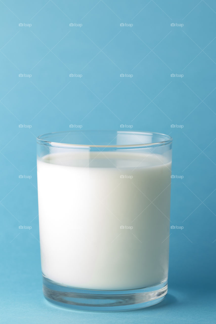 Glass milk on a blue background. source of calcium .Protein rich dairy product. healthy lifestyle concept .