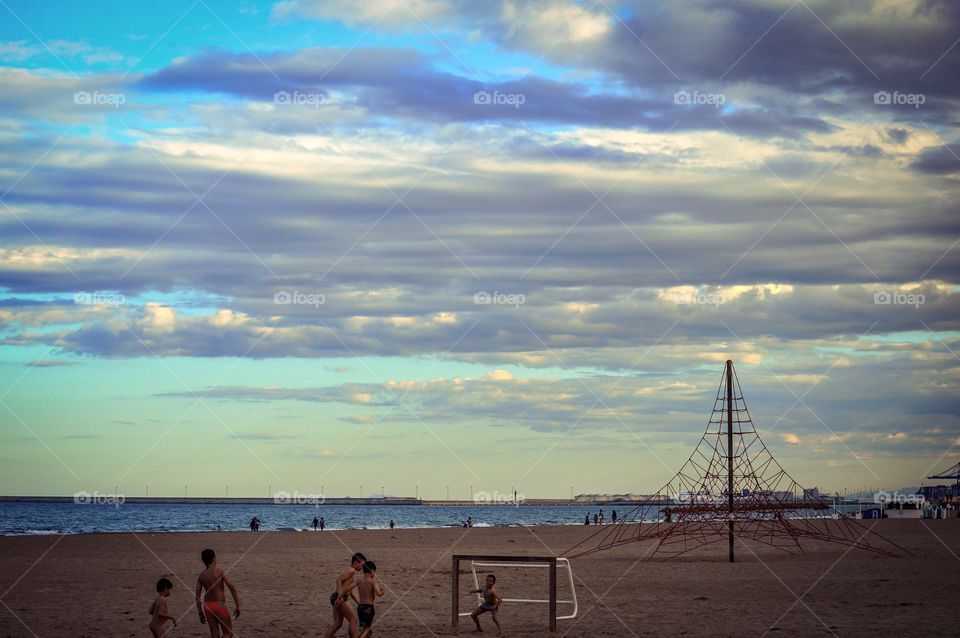 Children playing on beach at sunset