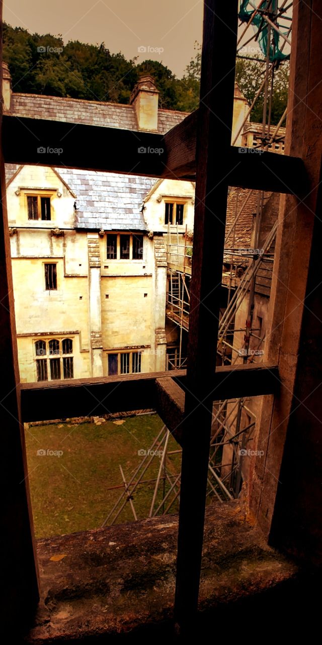 gothic mansion framed through window, spooky abandoned building