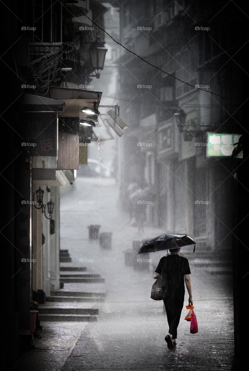 Walking under a heavy rain in street